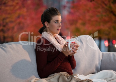 Woman in Autumn with cup in surreal red trees and lights