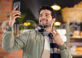 Man with phone in cafe taking selfie