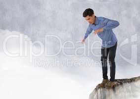 Businessman standing on rock with clouds
