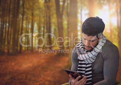 Man in Autumn with tablet in forest