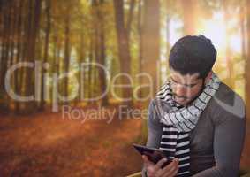 Man in Autumn with tablet in forest