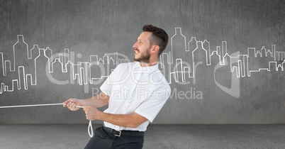 Businessman pulling rope in room with city drawings