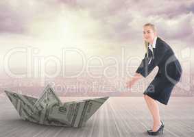 Businesswoman pulling paper boat with rope in city sky