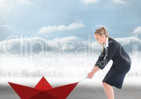 Businesswoman pulling paper boat with rope in city