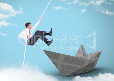Businesman swinging on rope with paper boat in sky