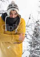 Man with folded arms and hat in snow fores