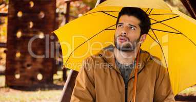 Man in Autumn with umbrella in wood park