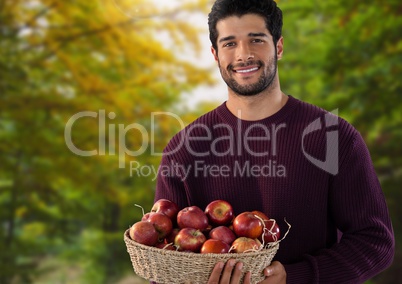 Man in Autumn with basket of apples in forest