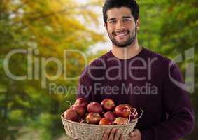 Man in Autumn with basket of apples in forest