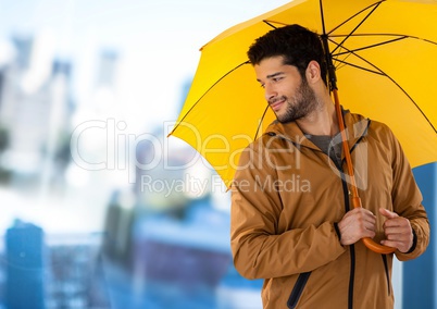 Man with yellow umbrella and blurred blue background