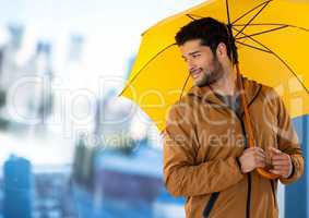 Man with yellow umbrella and blurred blue background