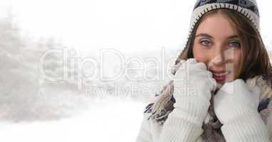 Woman wearing gloves and hat in bright snow forest