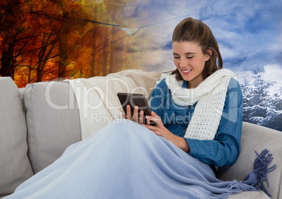 Woman in Autumn and Winter transition with tablet and scarf in forest