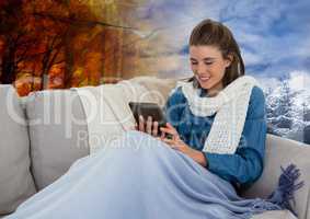 Woman in Autumn and Winter transition with tablet and scarf in forest