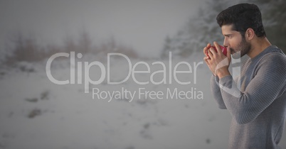 Man drinking from cup in snow landscape