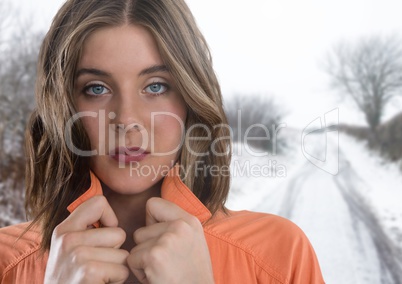 Woman holding her jumper tight keeping warm in snow countryside