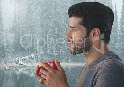 Man reflecting with cup in snow forest
