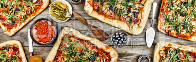 Appetizing homemade pizza on a wooden table. Friendly feast at home.