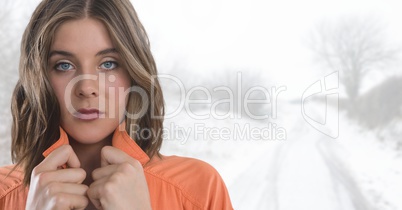 Woman holding her jumper tight keeping warm in bright snow countryside