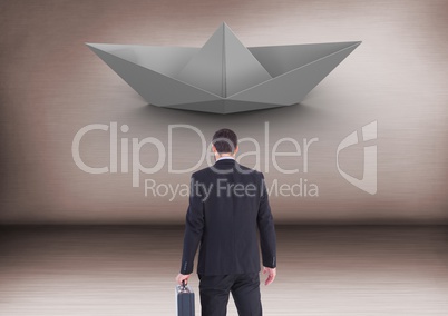 Businessman with briefcase and paper boat