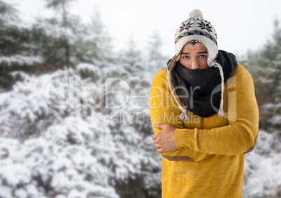 Man keeping warm with hat and scarf in snow forest