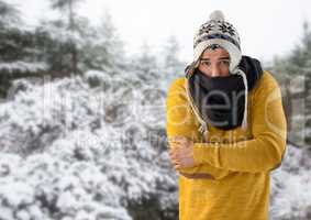 Man keeping warm with hat and scarf in snow forest