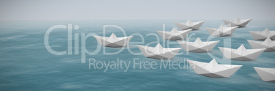 Composite image of paper boats arranged on white background