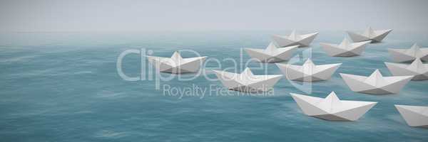 Composite image of paper boats arranged on white background
