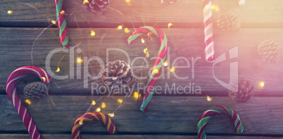 Overhead view of candy canes and pine cones on table