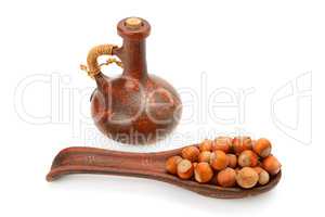 nuts and nut oil in clay bottle isolated on white background