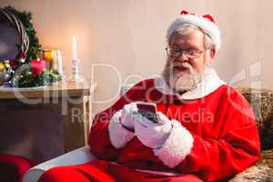 Santa claus sitting and using mobile phone