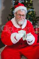 Santa claus sitting on the floor and counting cash at home