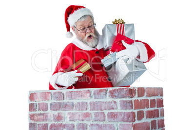 Santa claus placing gift box into a chimney