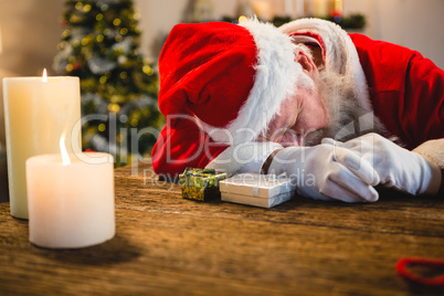 Santa claus sleeping at table at home