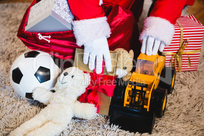 Santa claus arranging gifts in living room at home