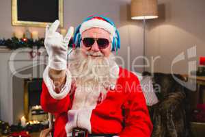 Santa claus listening to music on headphones at home