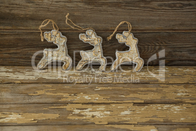 Reindeer decorations against wooden plank