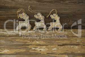 Reindeer decorations against wooden plank