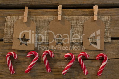 High angle view of star shape decoration with burlap and clothespin by candy canes