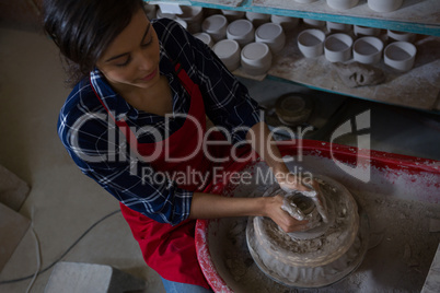 Overhead of female potter molding a clay