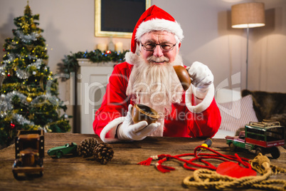 Smiling santa claus showing wooden bowl at home during christmas time