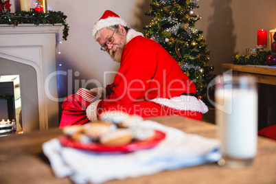 Santa Claus putting presents in christmas bag