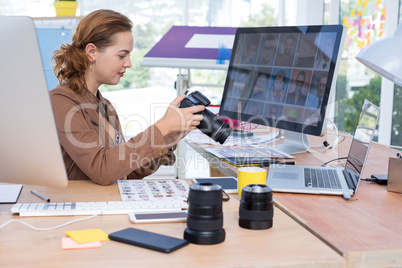 Female executive reviewing captured photograph at her desk