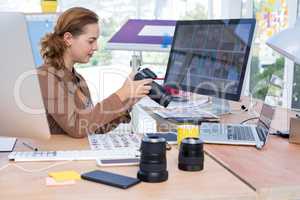 Female executive reviewing captured photograph at her desk