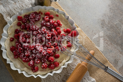 Red berries on tart with whisker and rolling pin