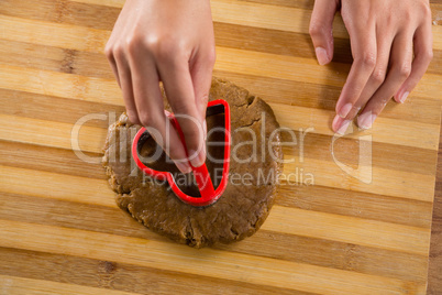 Man molding gingerbread dough on wooden board
