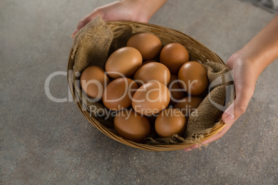 Woman holding basket with brown eggs Woman holding basket with brown eggs