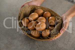 Woman holding basket with brown eggs