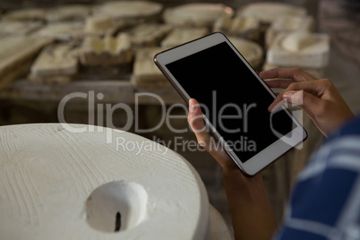 Close-up of female potter using digital tablet