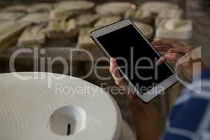 Close-up of female potter using digital tablet